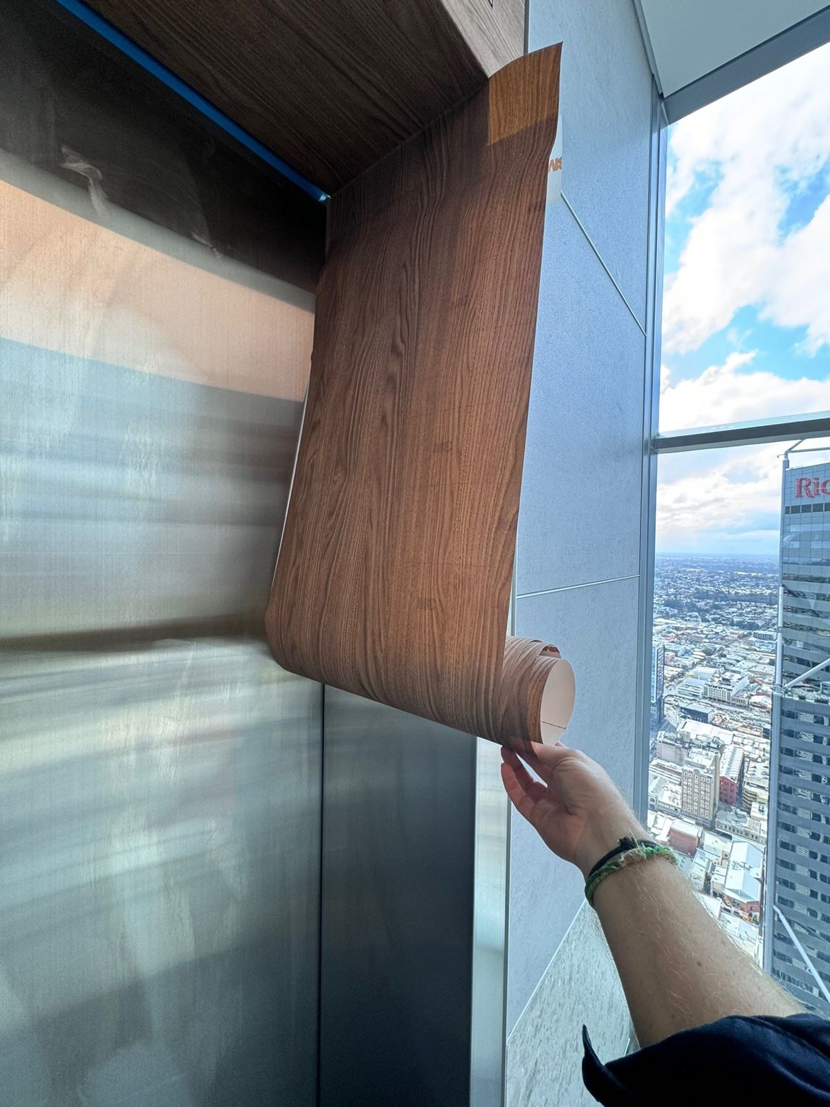 Installation in progress: Lift doors and frame, stainless to timber woodgrain