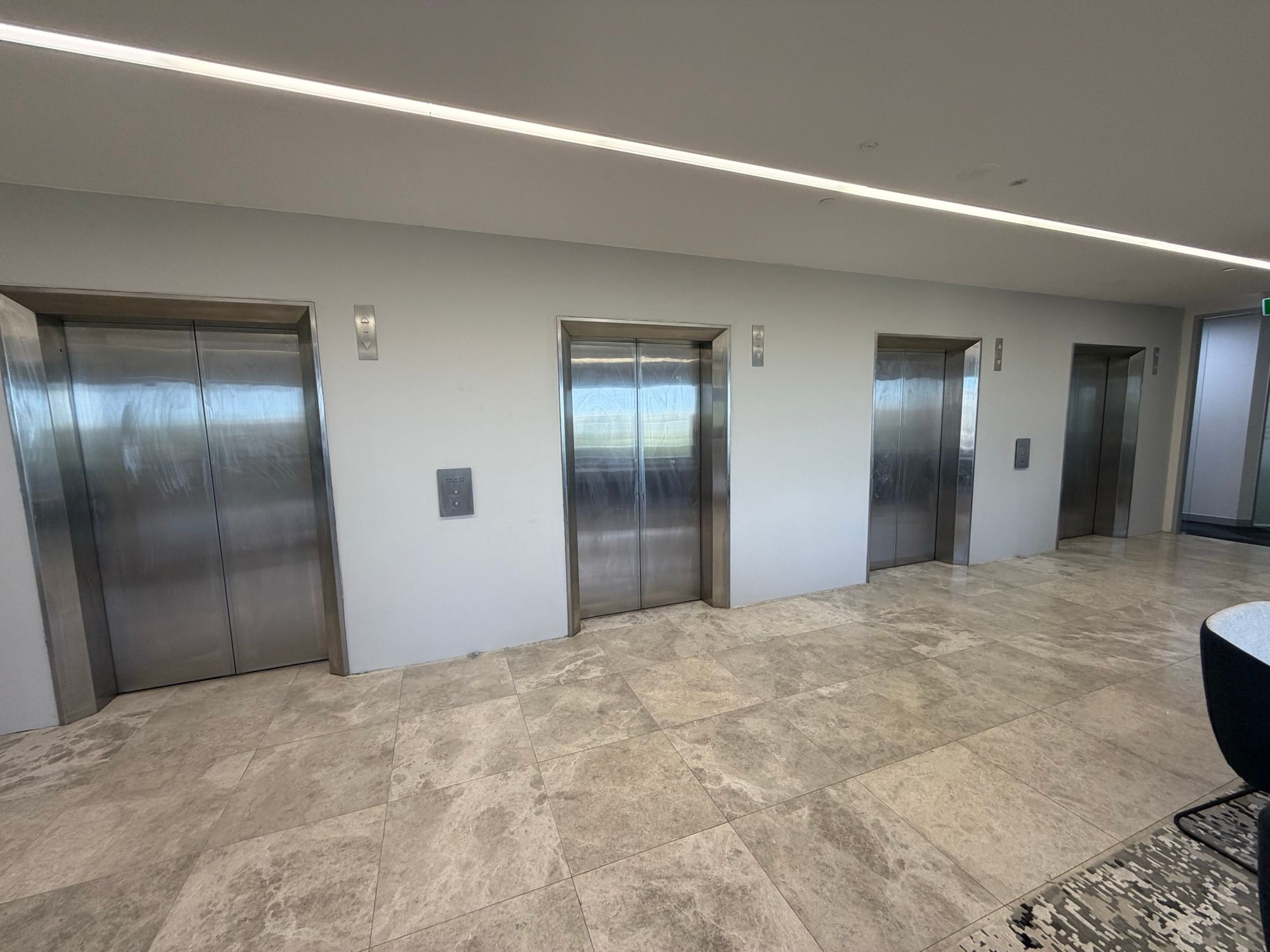 Before: Lift lobby, four sets of doors in matte black