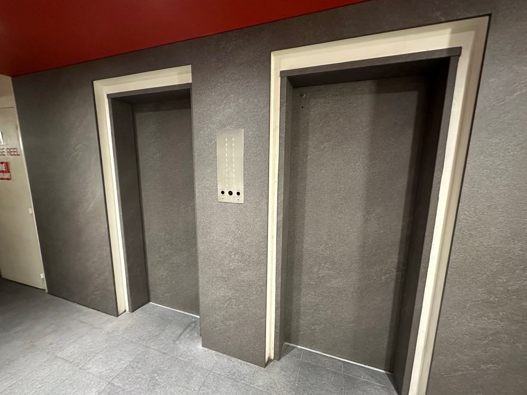 After: Lift lobby, feature wall and doors to grey stone look