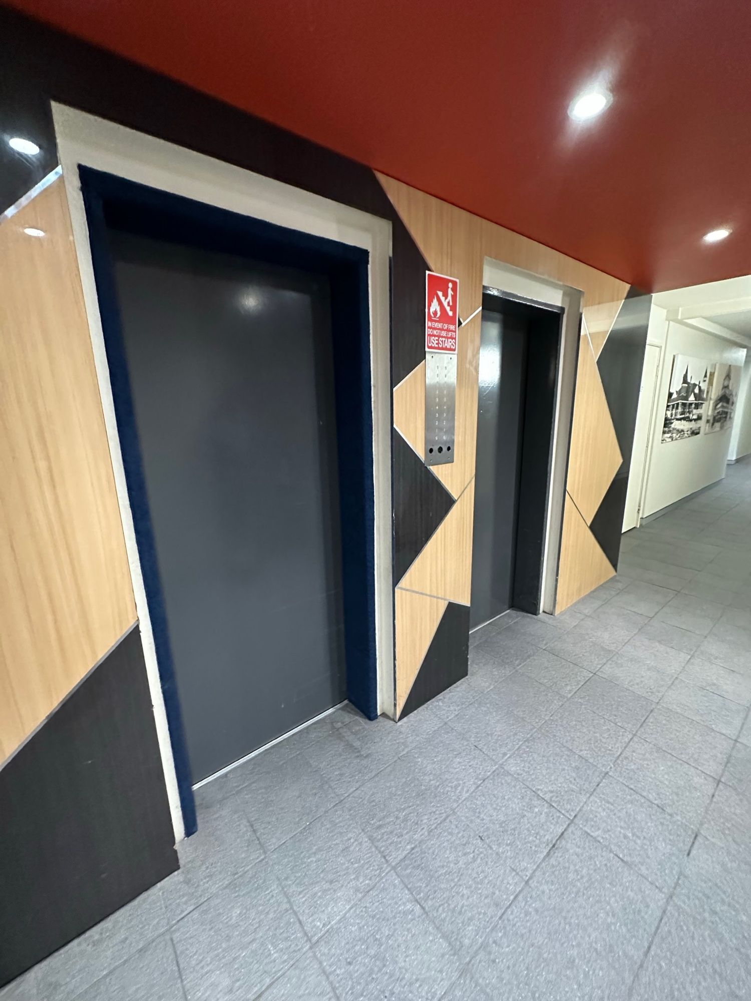 Before: Lift lobby, feature wall and doors to grey stone look