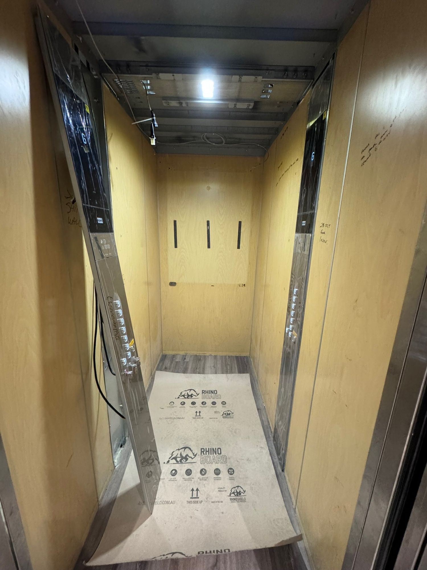 Before: Lift car, raw plywood to light woodgrain