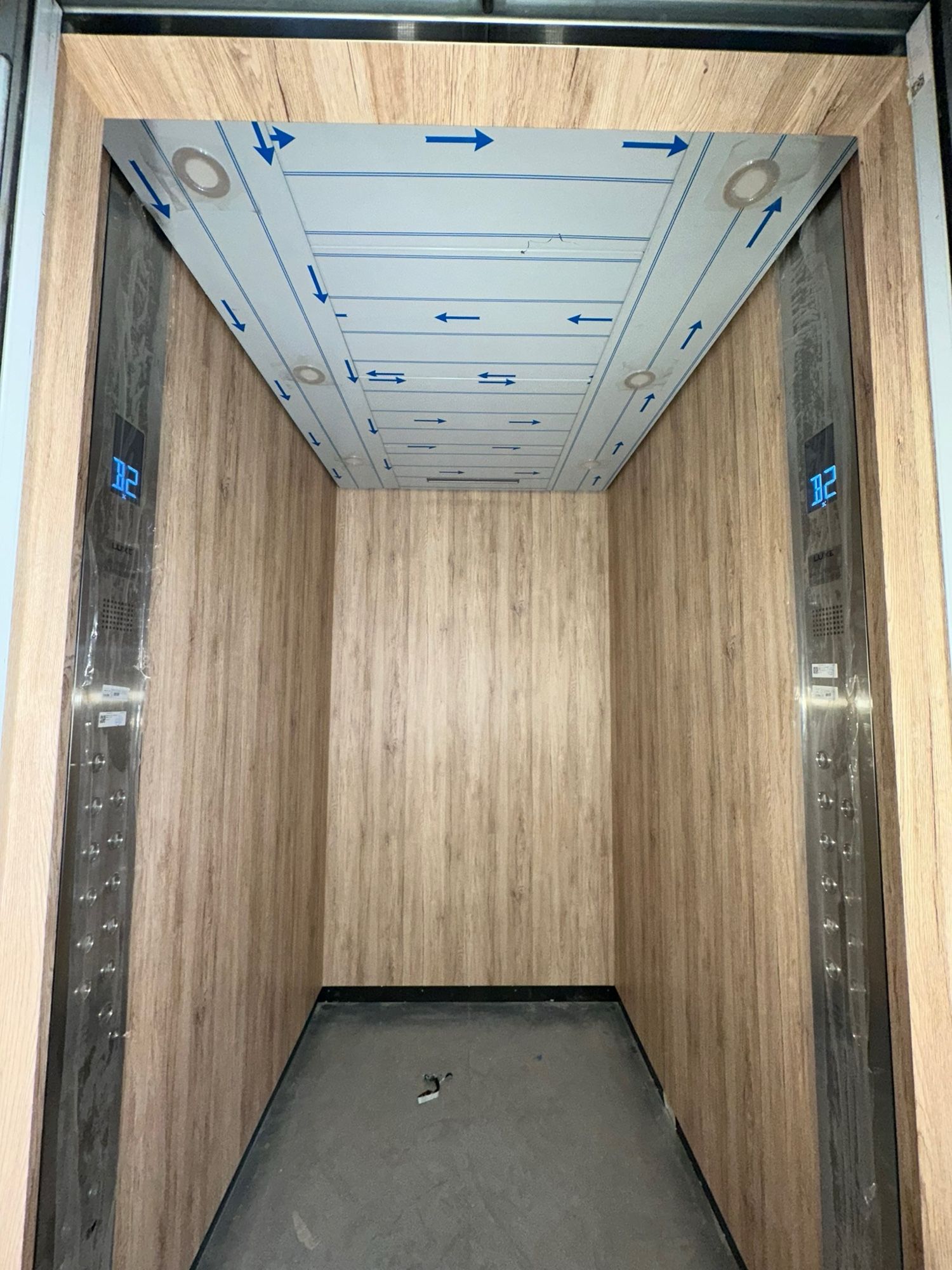 After: Lift car, stainless to light woodgrain