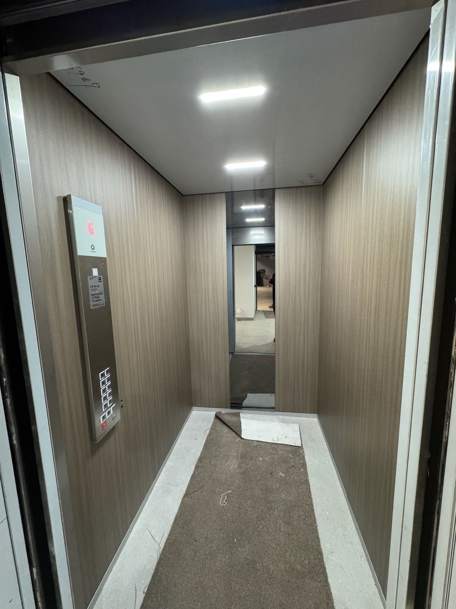 After: Lift car walls, white to light woodgrain