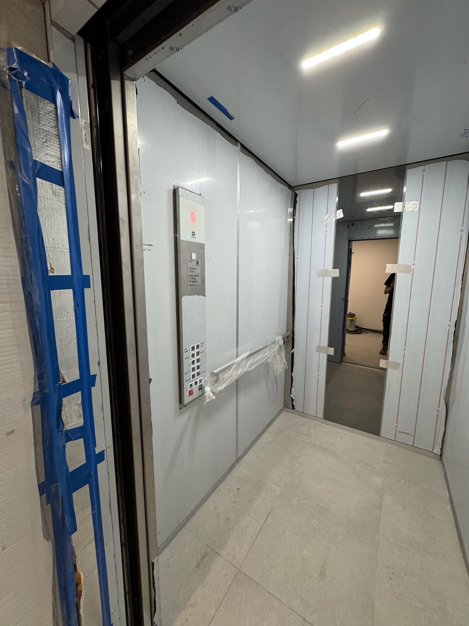 Before: Lift car walls, white to light woodgrain