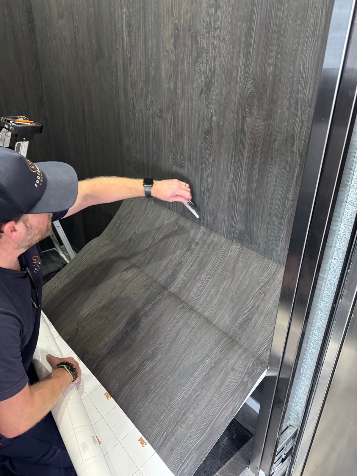 Installation in progress: Lift car, stainless to dark woodgrain