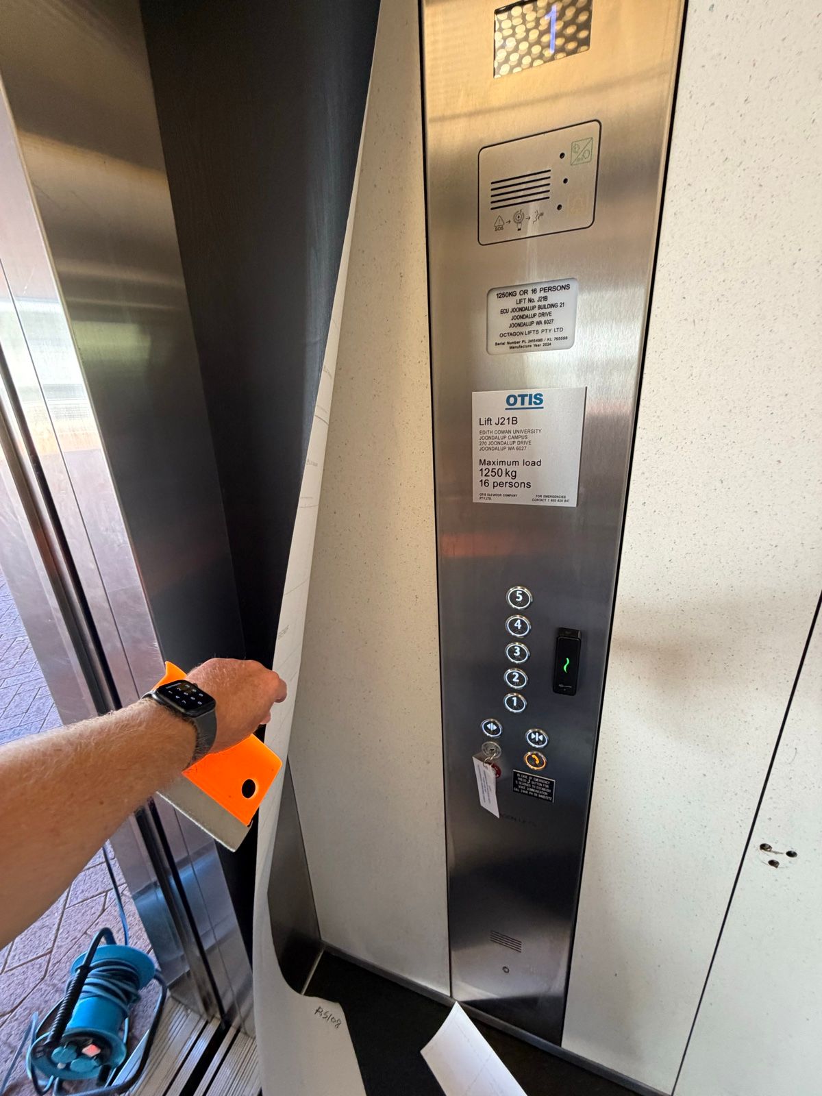 Installation in progress: Lift car, cream panels to dark woodgrain