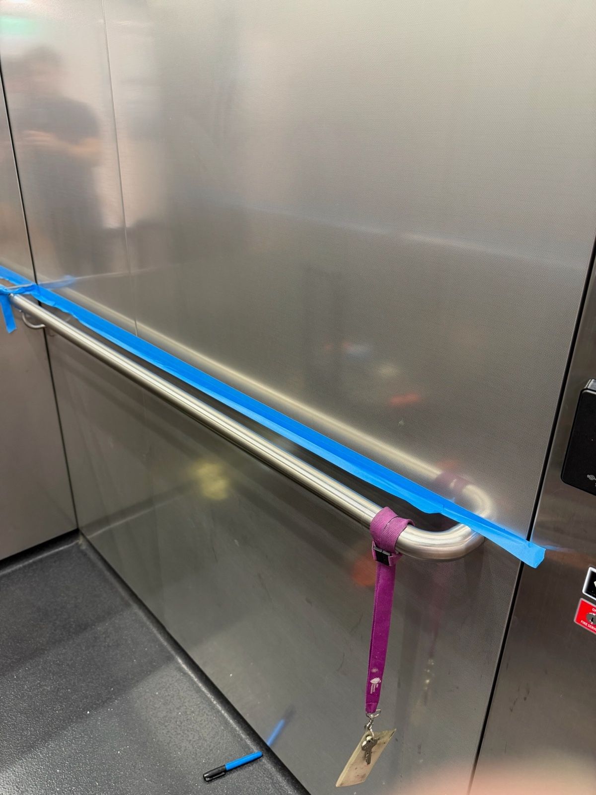 Installation in progress: Lift car, stainless to light woodgrain