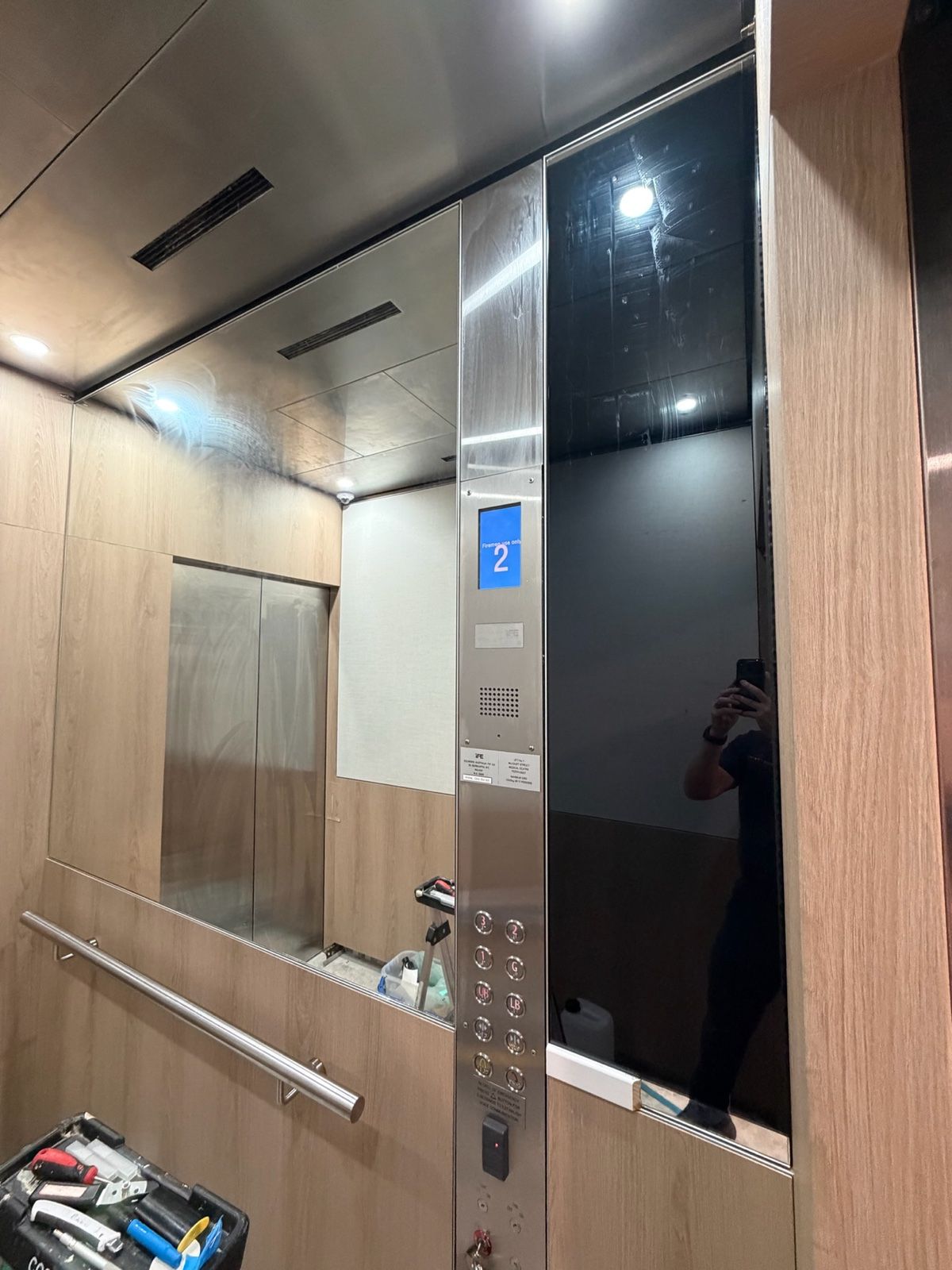 Installation in progress: Lift car, stainless to linen with an oak-look dado