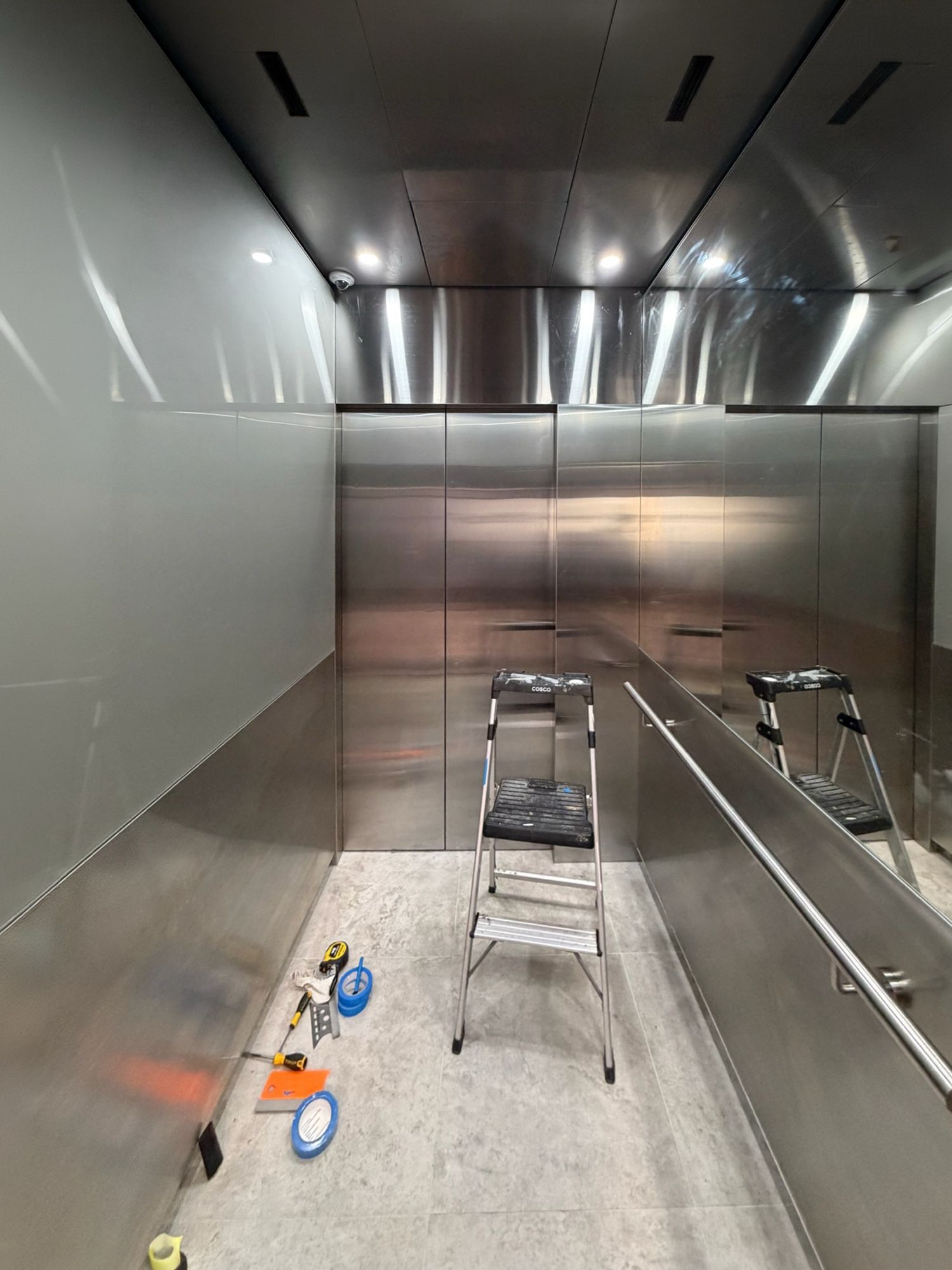 Before: Lift car, stainless to linen with an oak-look dado