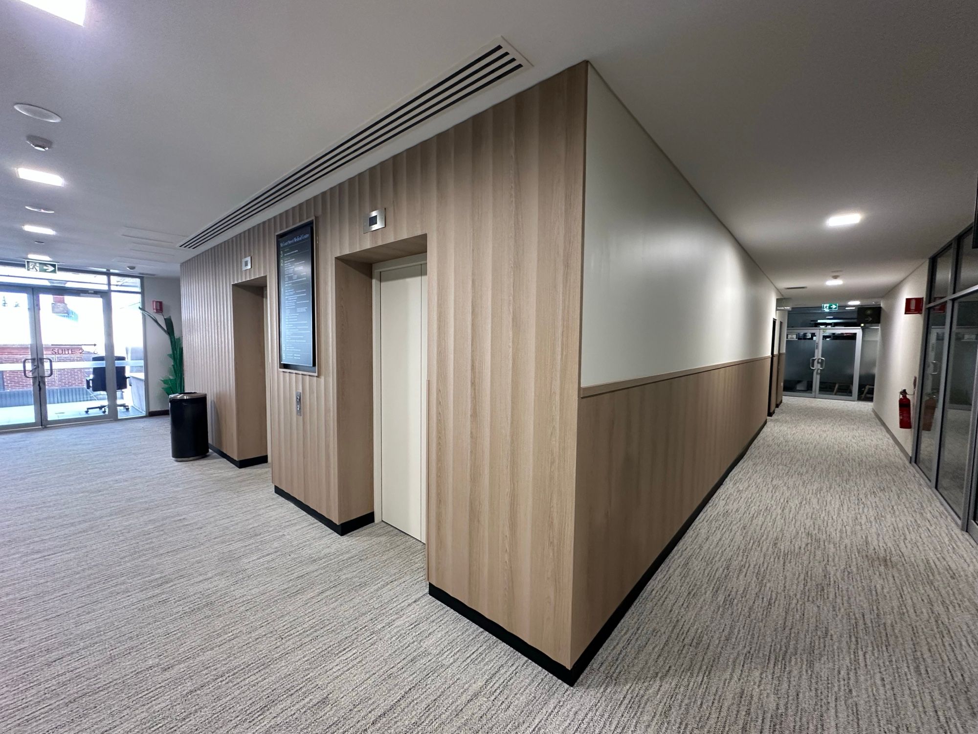 After: Lift lobby, stainless doors to oak-look walls