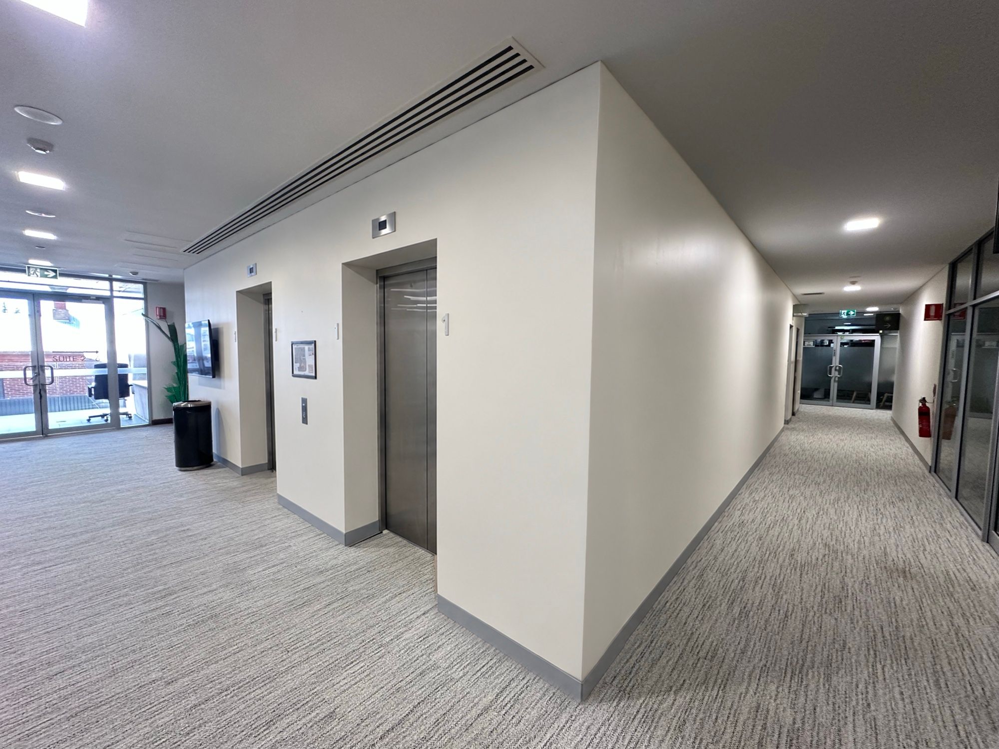 Before: Lift lobby, stainless doors to oak-look walls
